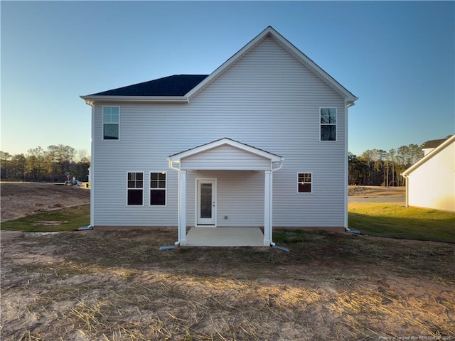 back of house featuring a patio and a lawn