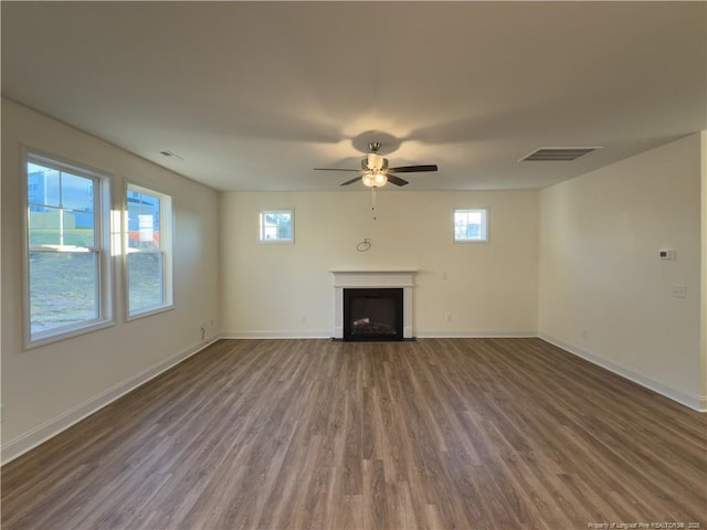 unfurnished living room with baseboards, a fireplace with flush hearth, and wood finished floors