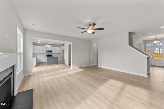 unfurnished living room featuring light wood-type flooring and ceiling fan