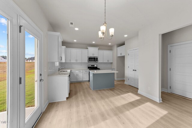 kitchen with white cabinets, a center island, a wealth of natural light, and stainless steel appliances