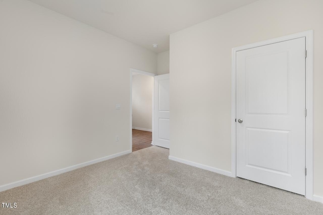 unfurnished room featuring light colored carpet