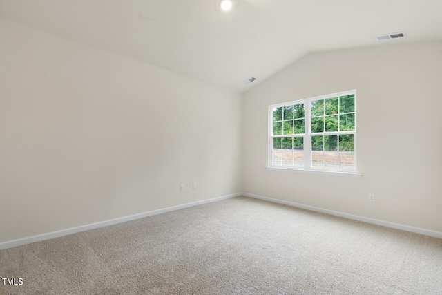 carpeted empty room with lofted ceiling