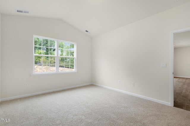 carpeted empty room featuring lofted ceiling