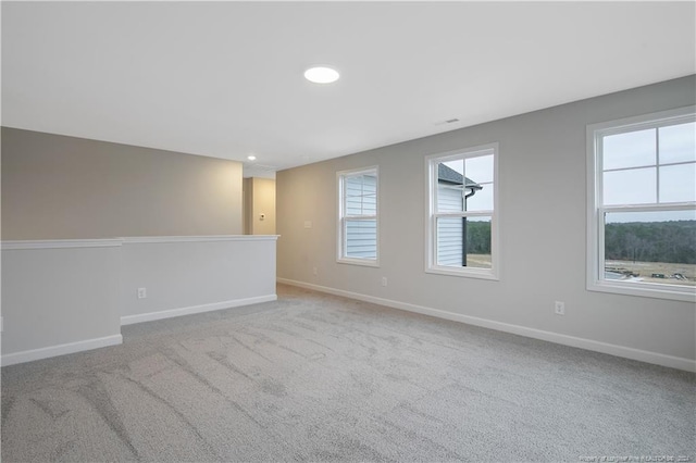 unfurnished room with light colored carpet and a healthy amount of sunlight