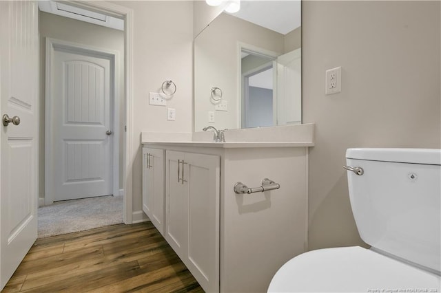 bathroom with hardwood / wood-style flooring, vanity, and toilet