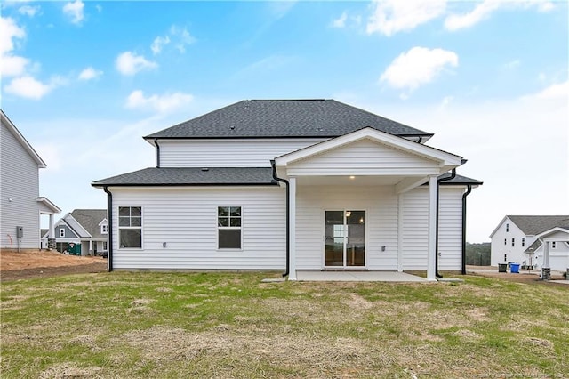 back of property with a yard and a patio