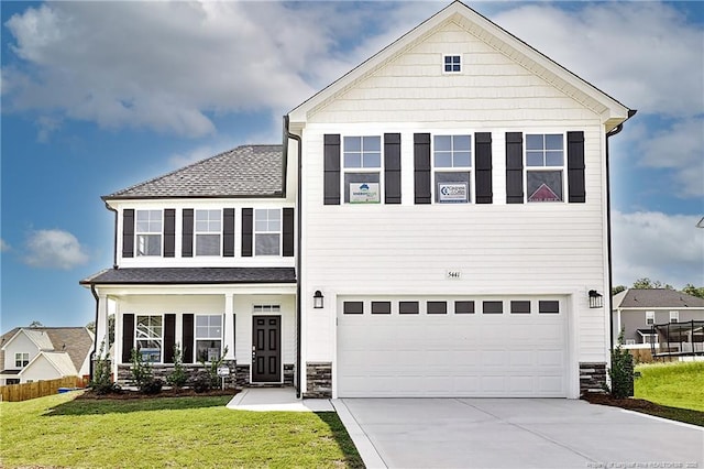 - traditional-style home featuring a front yard, a garage, driveway, and a shingled roof