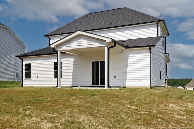  - back of property with a lawn and roof with shingles