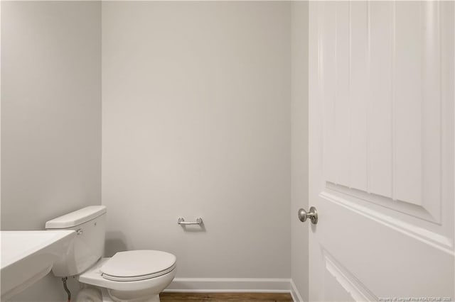  - bathroom featuring baseboards and toilet