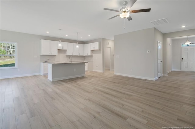 kitchen with pendant lighting, light countertops, visible vents, open floor plan, and white cabinetry