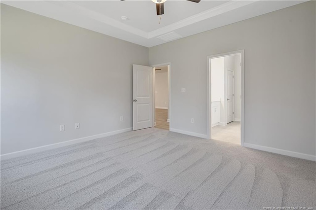 unfurnished bedroom with baseboards, ensuite bathroom, a ceiling fan, and light colored carpet