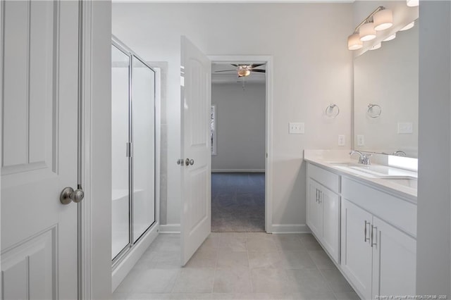 bathroom featuring a ceiling fan, a stall shower, vanity, tile patterned flooring, and baseboards