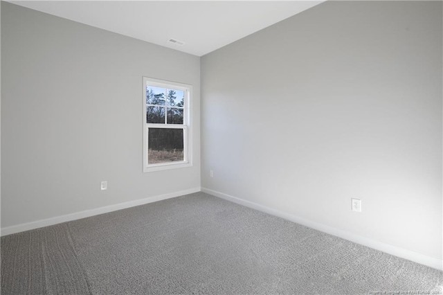 empty room featuring carpet, visible vents, and baseboards