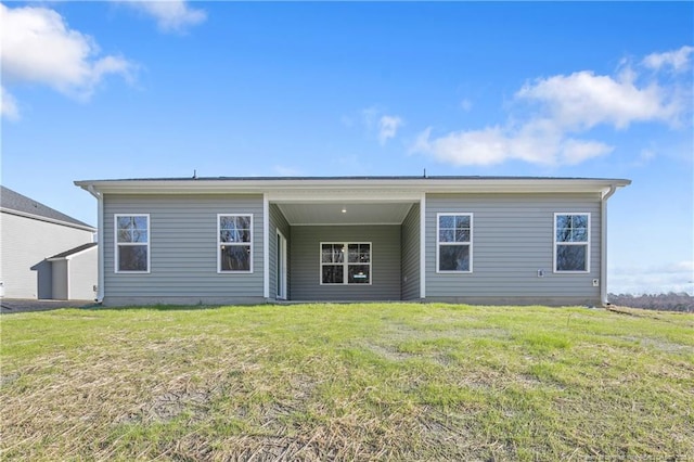 rear view of house featuring a yard