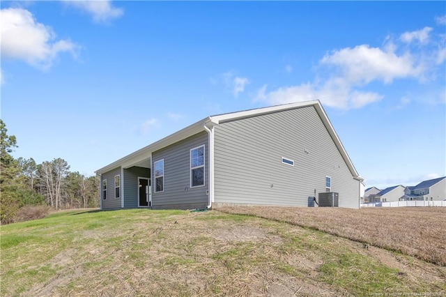 back of house with a yard and central air condition unit