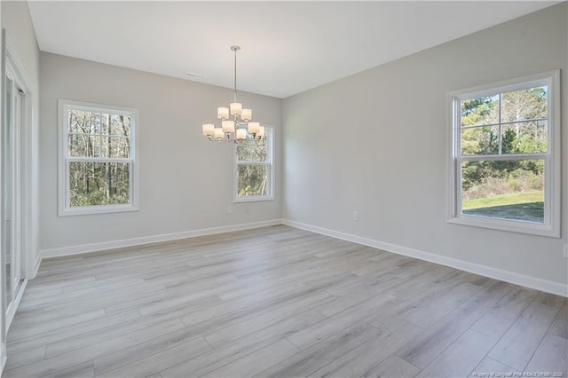 5513 Tall Timbers Dr, Fayetteville, NC 28311 - spare room featuring a chandelier, light wood-style flooring, and baseboards