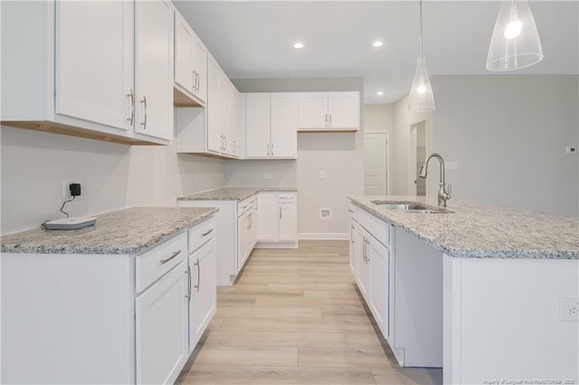 5513 Tall Timbers Dr, Fayetteville, NC 28311 - kitchen featuring a sink, light wood finished floors, light stone countertops, white cabinets, and recessed lighting