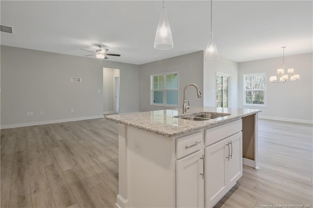 5513 Tall Timbers Dr, Fayetteville, NC 28311 - kitchen with a sink, light wood-type flooring, a ceiling fan, baseboards, and white cabinetry