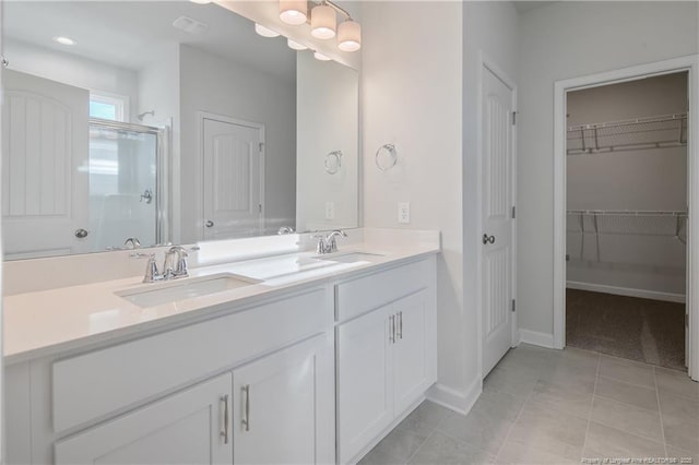 5513 Tall Timbers Dr, Fayetteville, NC 28311 - bathroom with double vanity, a shower stall, a walk in closet, baseboards, and tile patterned floors