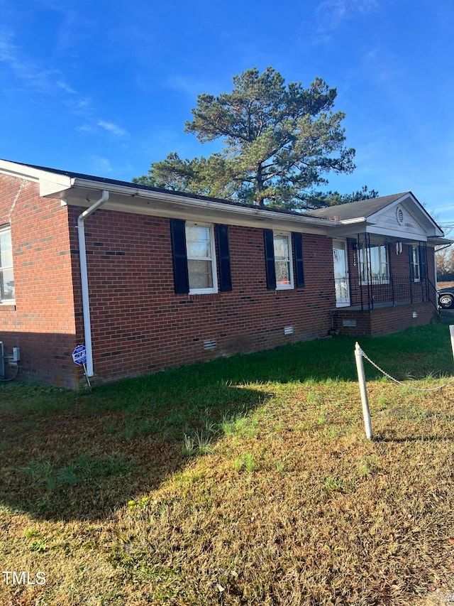 rear view of property with central air condition unit and a lawn