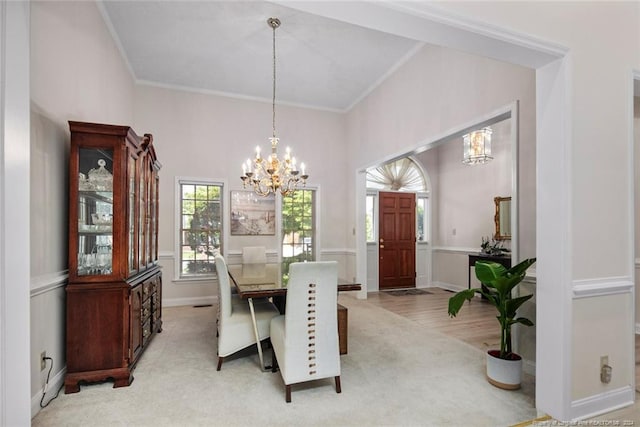 dining space featuring crown molding, light carpet, and a chandelier