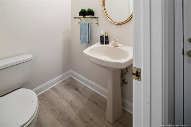 bathroom with hardwood / wood-style flooring and toilet