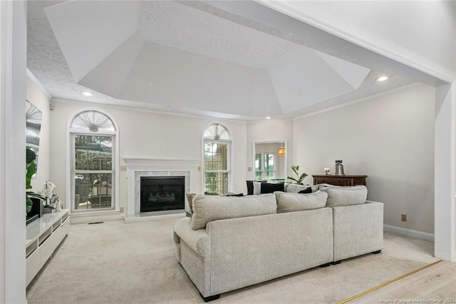 living room featuring plenty of natural light, light hardwood / wood-style floors, ornamental molding, and a high end fireplace