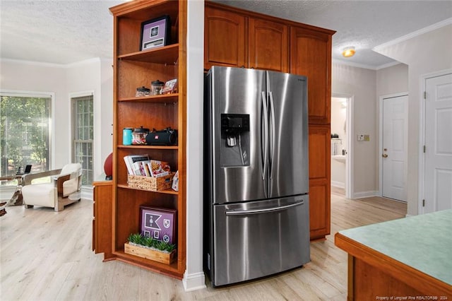 kitchen featuring stainless steel fridge, a textured ceiling, light hardwood / wood-style flooring, and crown molding