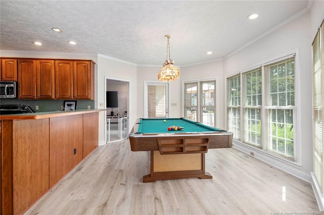 game room with a textured ceiling, light hardwood / wood-style floors, crown molding, and pool table