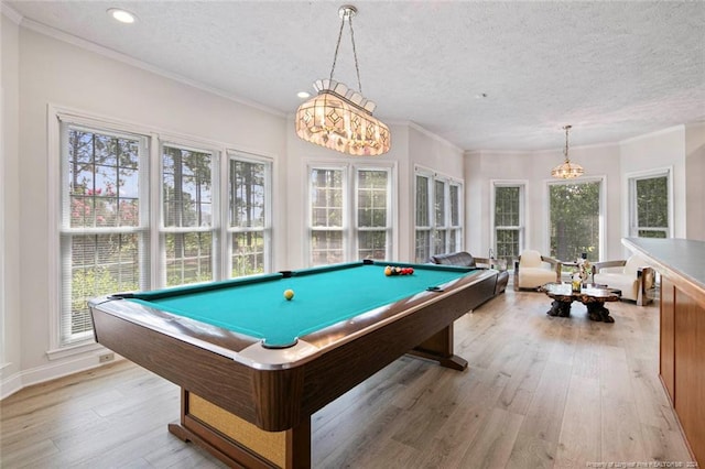 game room featuring a textured ceiling, light wood-type flooring, crown molding, and pool table