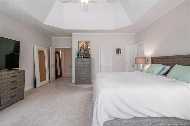 bedroom featuring light colored carpet, crown molding, ceiling fan, and a tray ceiling