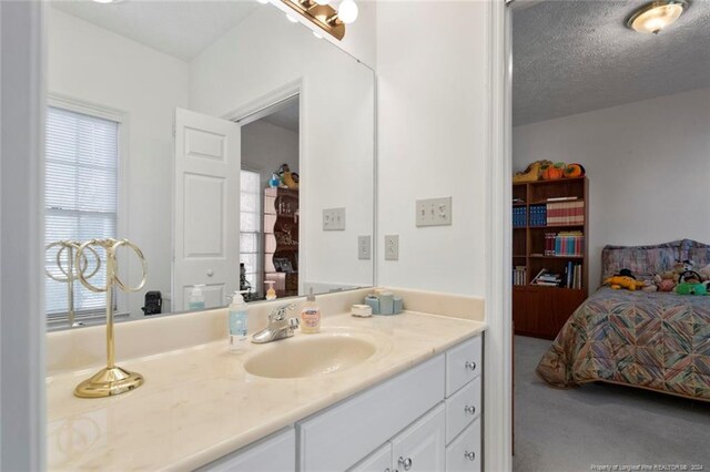 bathroom featuring plenty of natural light, vanity, and a textured ceiling