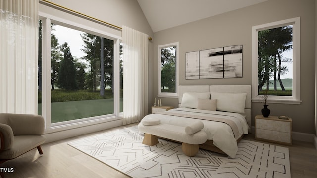 bedroom with wood finished floors and lofted ceiling