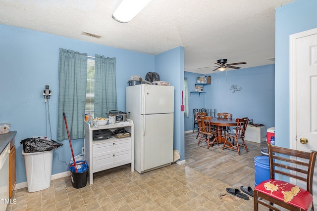 kitchen with light hardwood / wood-style flooring, a textured ceiling, ceiling fan, and white refrigerator