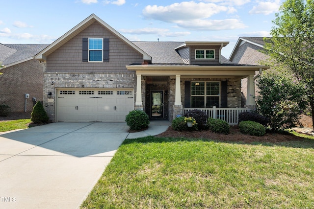 craftsman house with brick siding, a porch, a front yard, driveway, and an attached garage