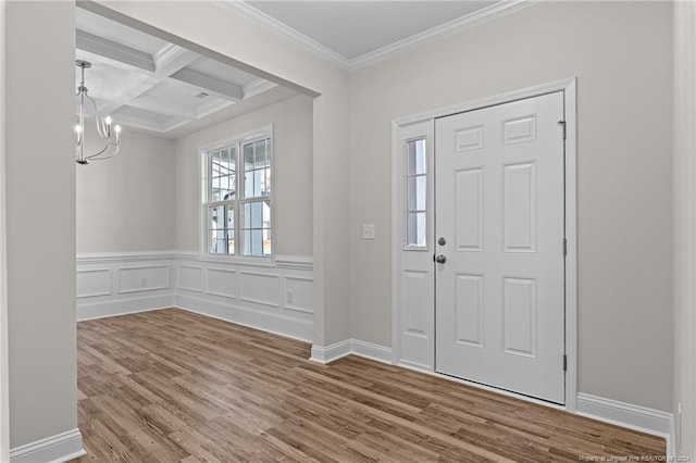 foyer entrance featuring wood-type flooring, beam ceiling, ornamental molding, and coffered ceiling