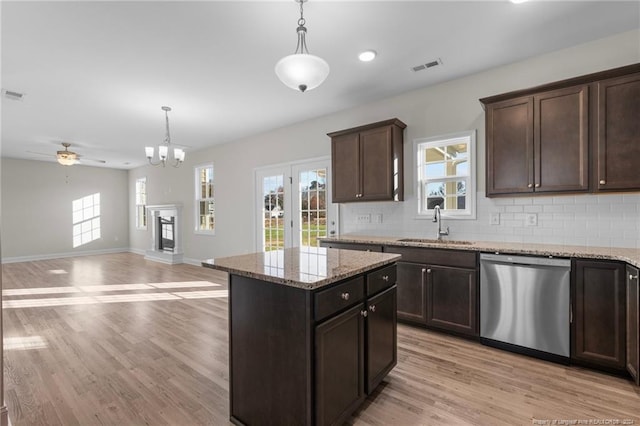 kitchen with dishwasher, decorative light fixtures, and light hardwood / wood-style flooring