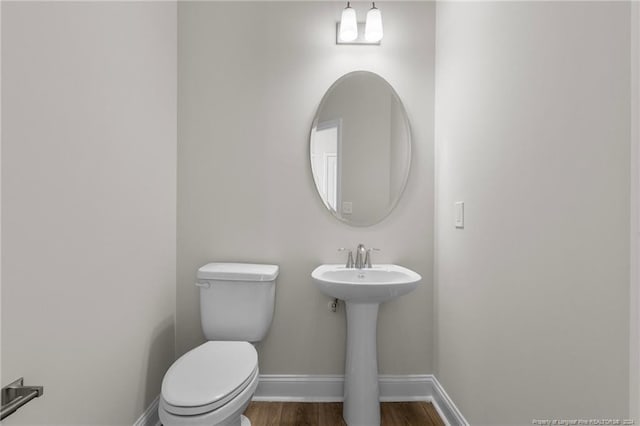 bathroom with hardwood / wood-style floors and toilet