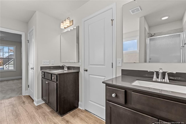 bathroom with hardwood / wood-style floors, vanity, and walk in shower