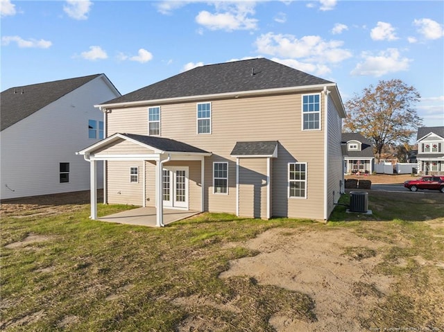 rear view of house featuring french doors, a yard, cooling unit, and a patio area