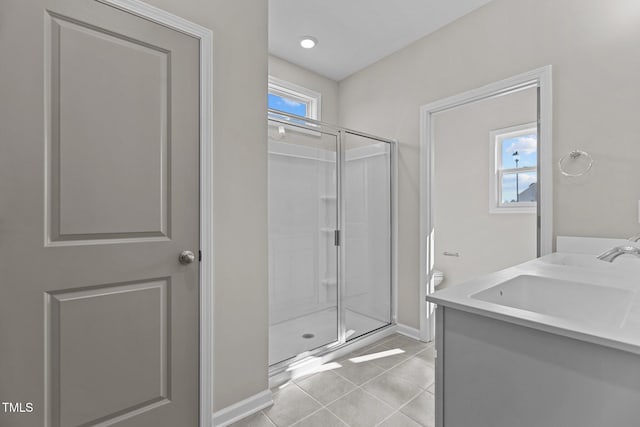 bathroom featuring a shower with shower door, vanity, and tile patterned flooring