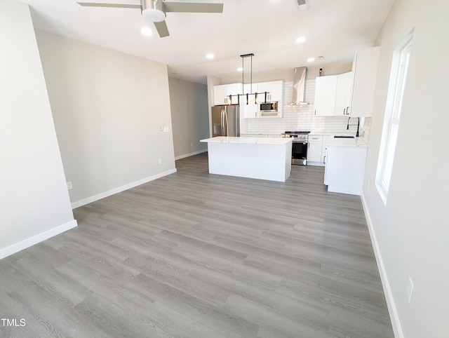 unfurnished living room featuring sink, light wood-type flooring, and ceiling fan