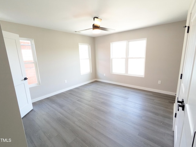 unfurnished room featuring a healthy amount of sunlight, hardwood / wood-style floors, and ceiling fan