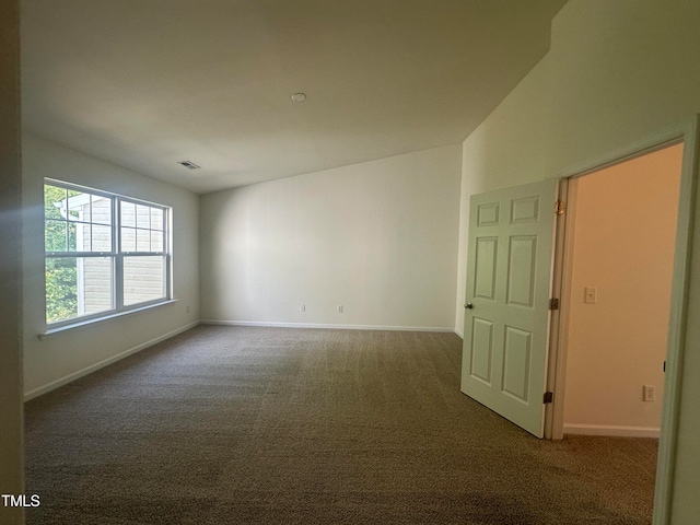 empty room with vaulted ceiling and carpet flooring