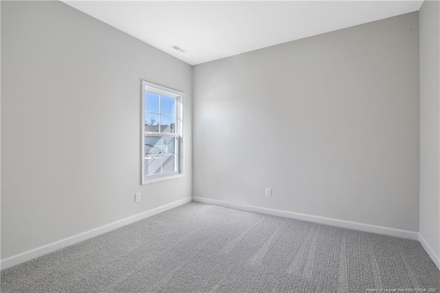 unfurnished room with baseboards, visible vents, and carpet flooring
