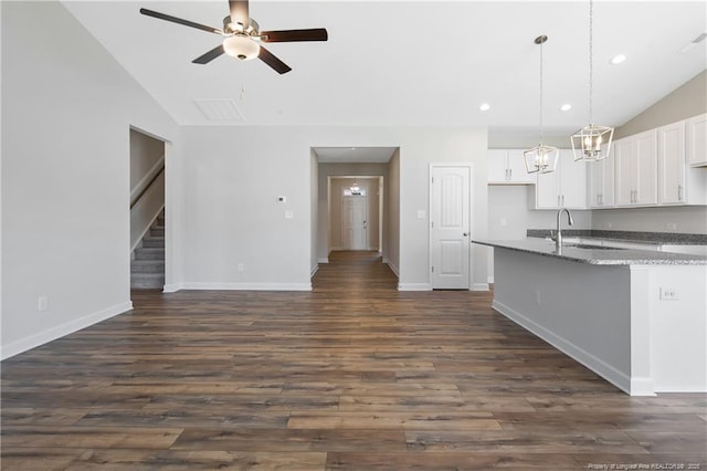 5411 Seedling Rd, Fayetteville, NC 28311 - kitchen featuring lofted ceiling, a ceiling fan, white cabinets, dark wood-type flooring, and light stone counters