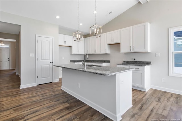 5411 Seedling Rd, Fayetteville, NC 28311 - kitchen with a sink, stone countertops, white cabinetry, a center island with sink, and dark wood-style floors