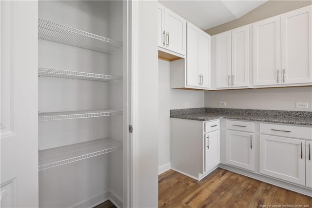 5411 Seedling Rd, Fayetteville, NC 28311 - kitchen featuring dark wood finished floors, white cabinets, dark stone counters, and baseboards