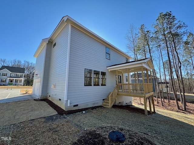 rear view of house featuring a porch and a garage