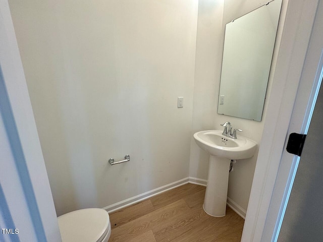 bathroom with toilet and hardwood / wood-style flooring